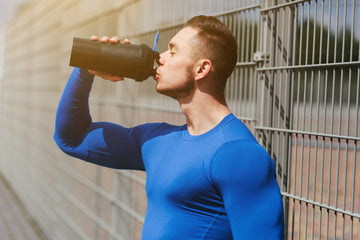 jonge sporter drinkt pre workout voordat hij begint met sporten
